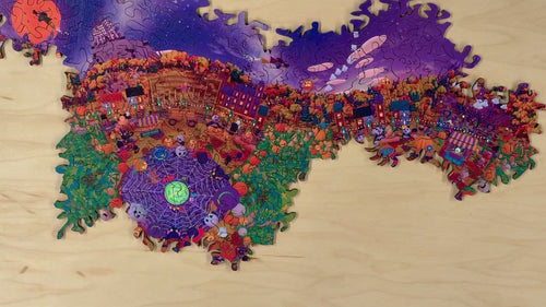 Hands rearranging sections of the Festival at Shiver Falls infinity puzzle into a new layout on a wooden table (sped up)