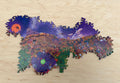 Festival at Shiver Falls infinity puzzle assembled on a wooden table: a Halloween town square with a glowing green cauldron, pumpkin patches, and a purple night sky with an orange moon, edged by curling, borderless pieces